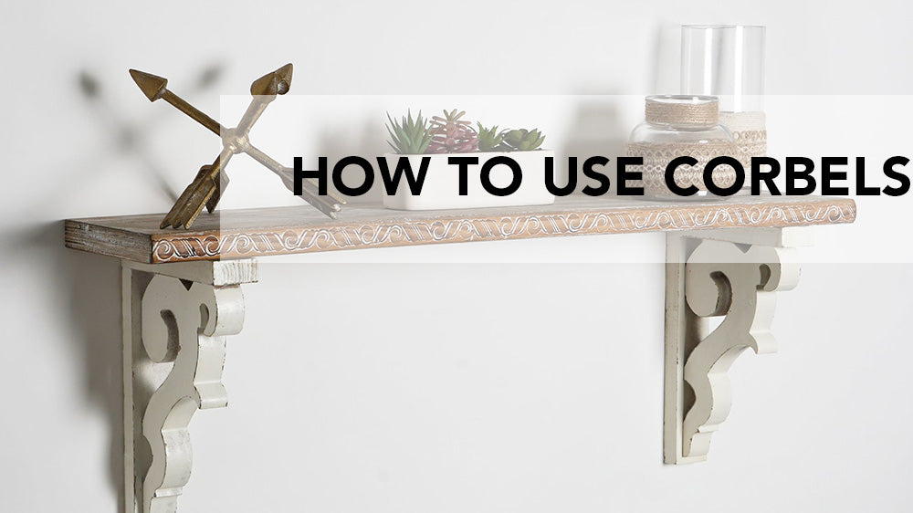 Header for Blog About How to Use Corbels Image is Shelf with Wooden Corbels Underneath Glass Jars and Vases with Bow and Arrow Paperweight