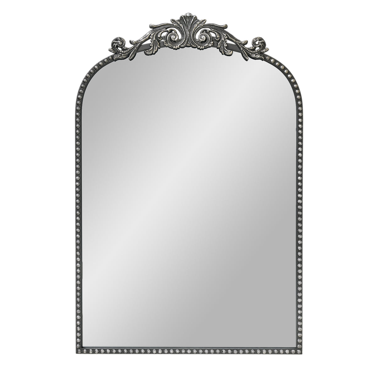 A 20 x 30 pewter arched vanity mirror with antique silver filigree crest and beaded edge, mounted vertically above a compact dresser in a bright neutral room.
