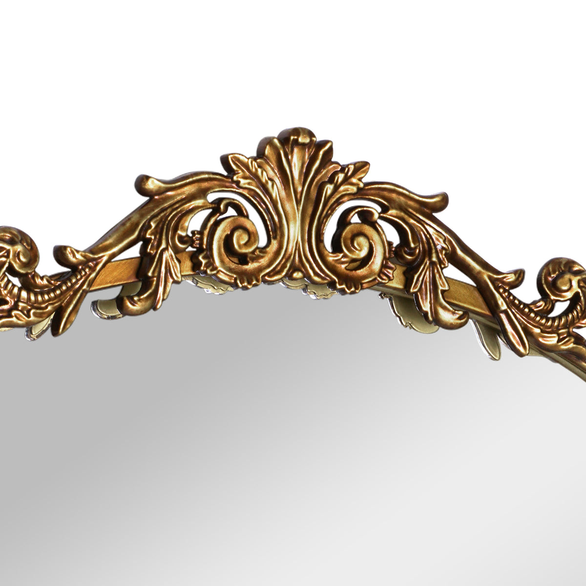 A compact 20 x 30 antique gold arched wall mirror with filigree crest and beaded trim, displayed vertically above a vanity for grooming in a warm dressing space.