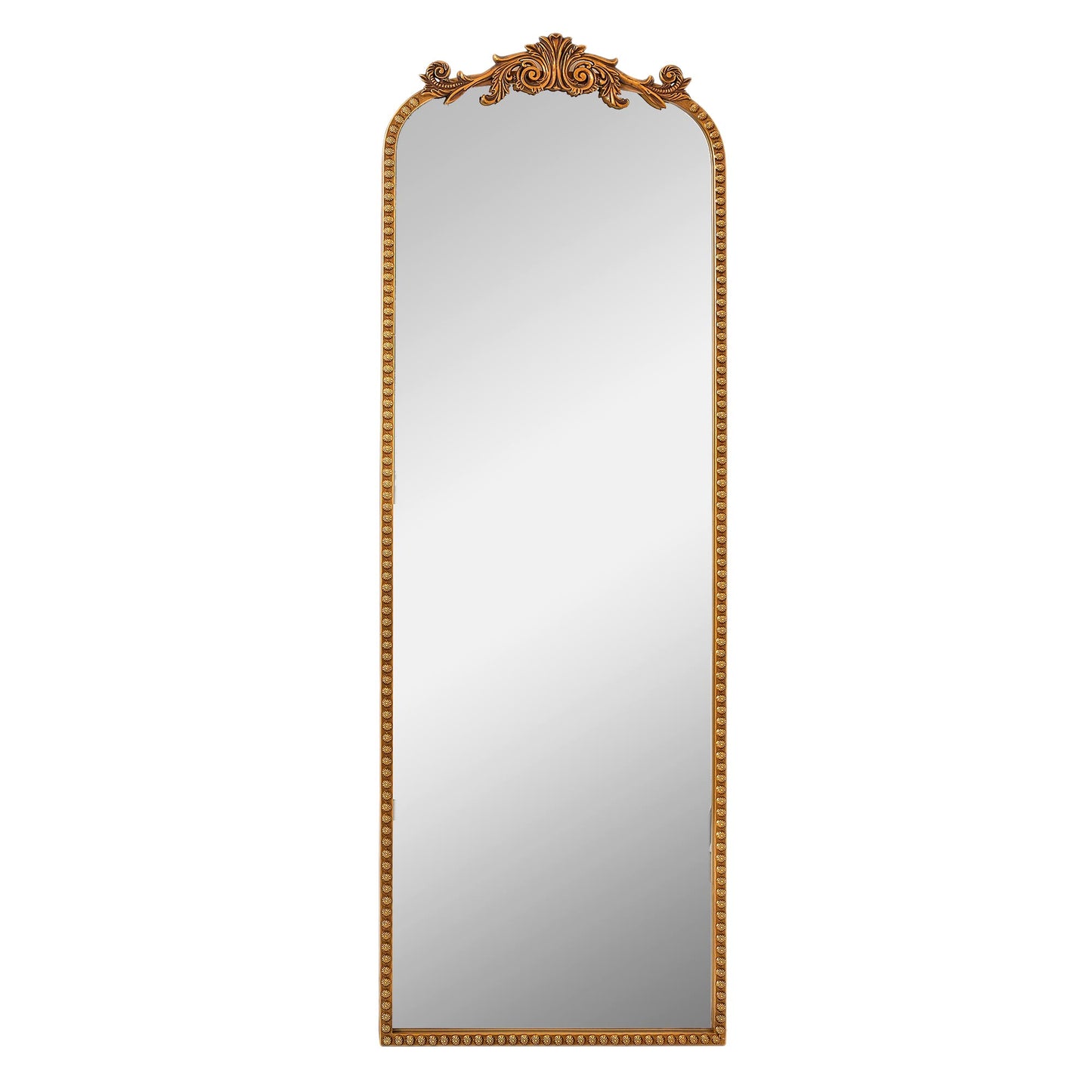 A slim 22 x 64 antique gold arched full body mirror with ornate filigree crest and floral-bead border, leaning beside a dresser and closet in a warm bedroom.