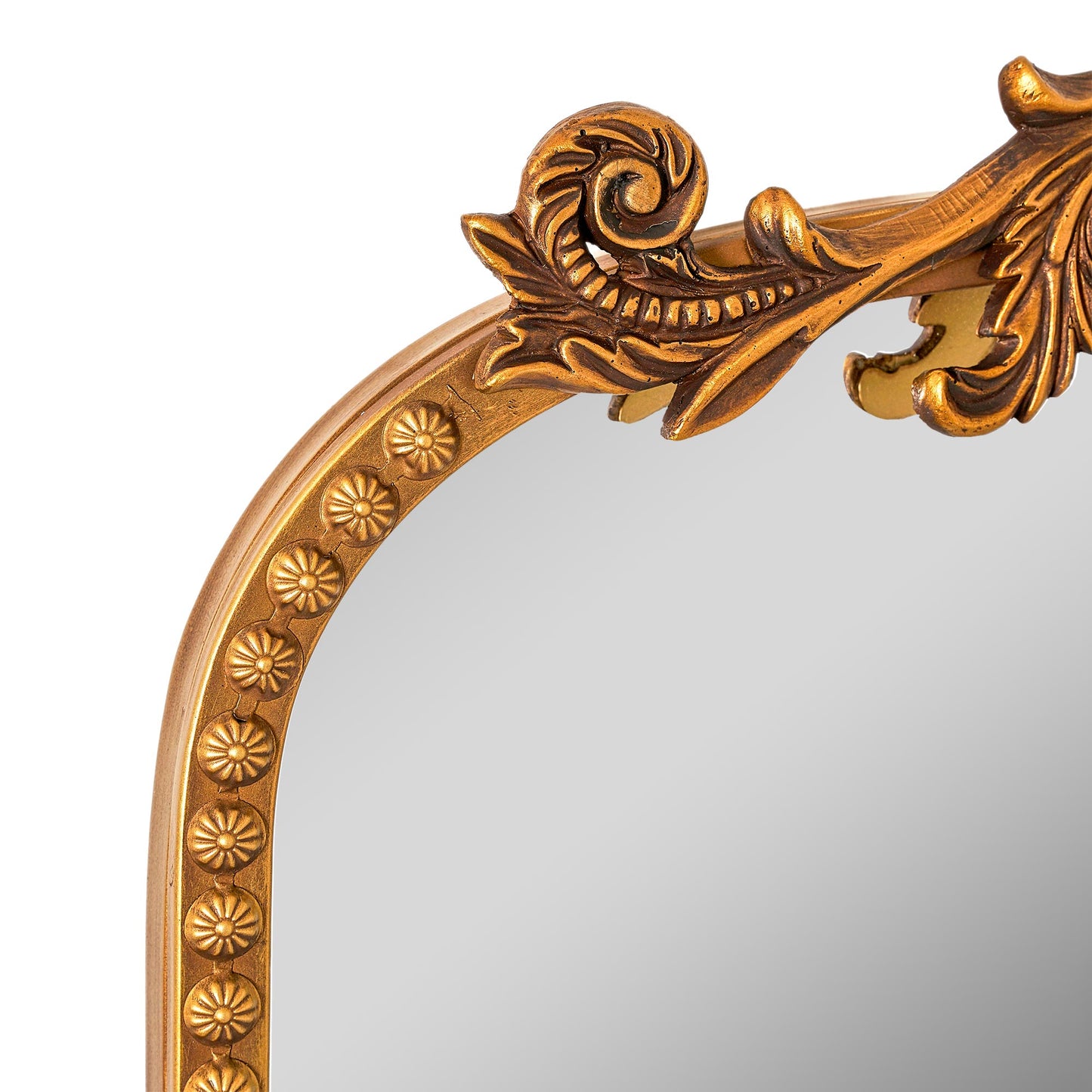 A slim 22 x 64 antique gold arched full body mirror with ornate filigree crest and floral-bead border, leaning beside a dresser and closet in a warm bedroom.