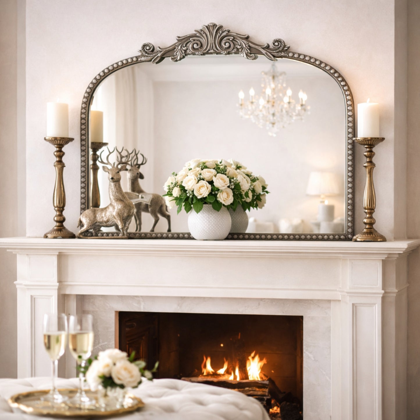 A 24 x 34 pewter arched wall mirror with antique silver filigree crest and beaded trim, displayed horizontally above a vanity or console in a polished neutral interior.